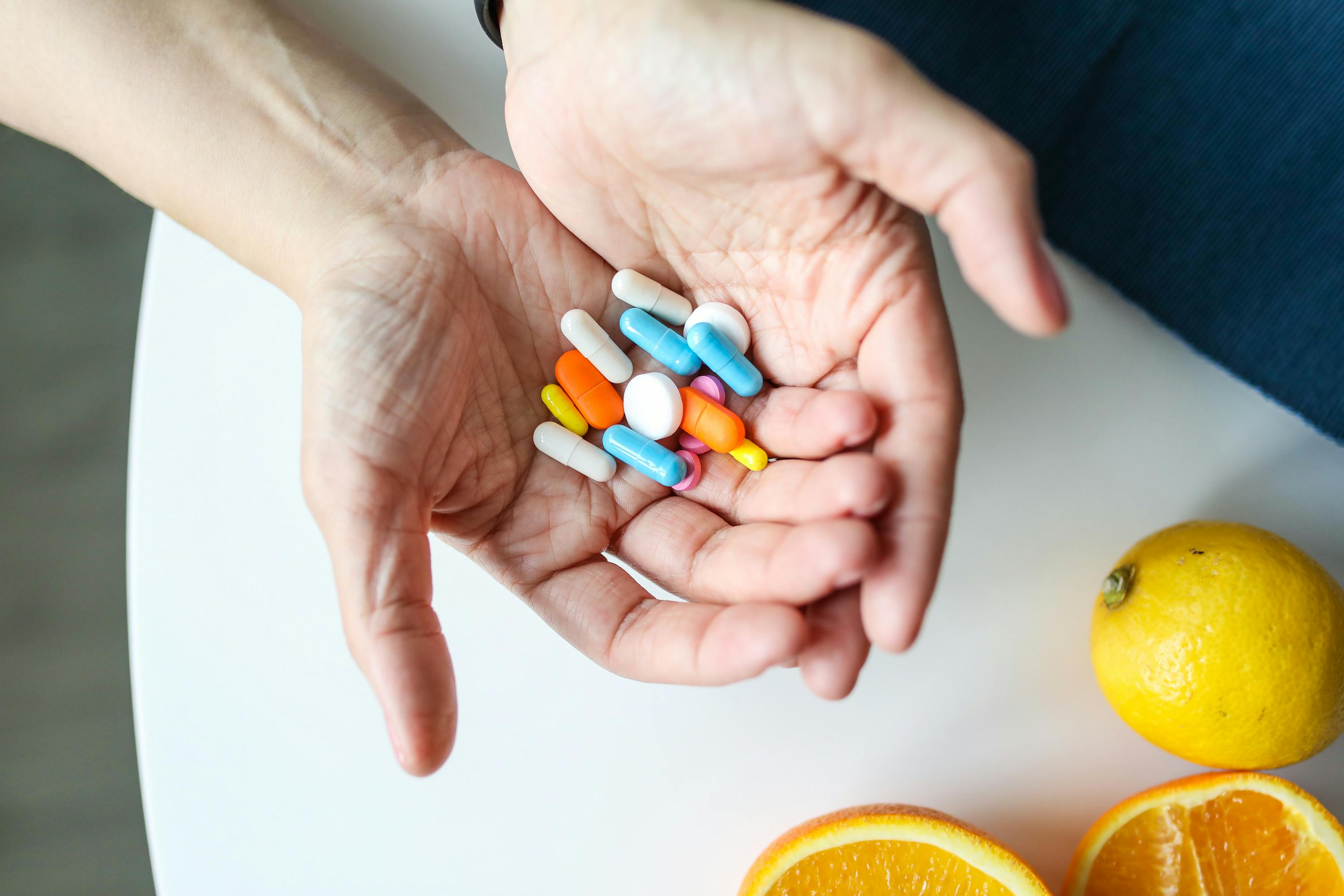 Hands holding colorful supplement capsules