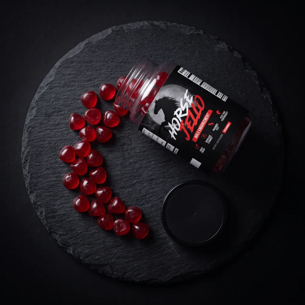 Horse Jello gummies and bottle on a dark slate surface — the daily male enhancement gummy built around a dose-matched 200 mg of Tongkat Ali